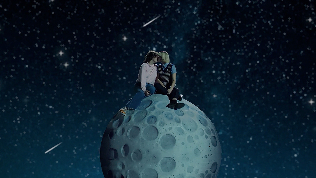 Image of a couple cuddling on top of the moon.